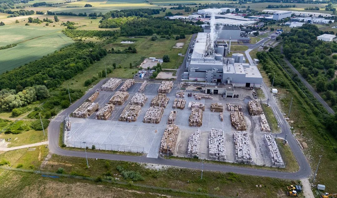 Luftbild eines Industriegeländes mit geordneten Ballenlagern und Produktionshalle