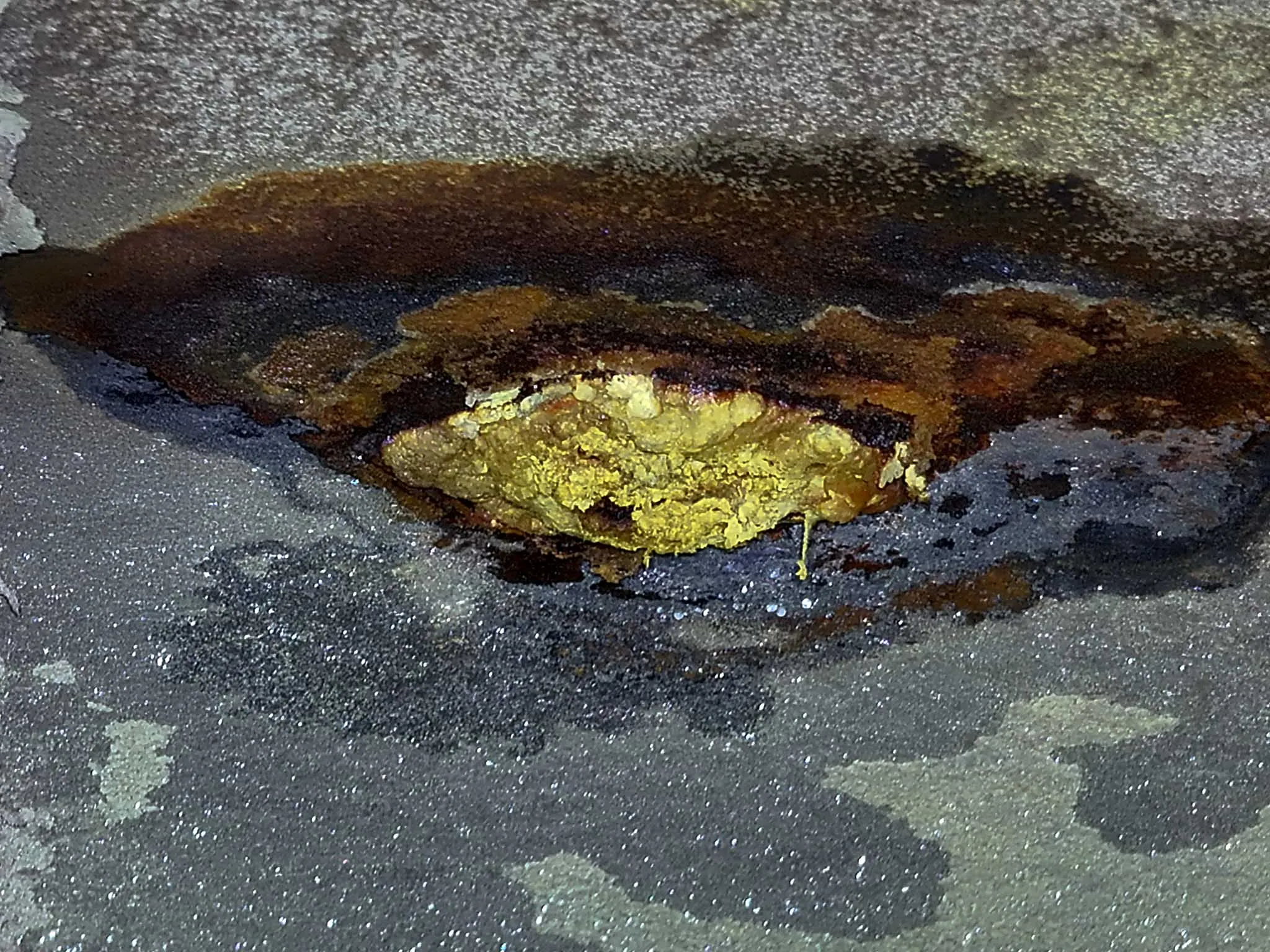 Nahaufnahme einer Korrosionsstelle mit Rostablagerungen auf einer Stahloberfläche